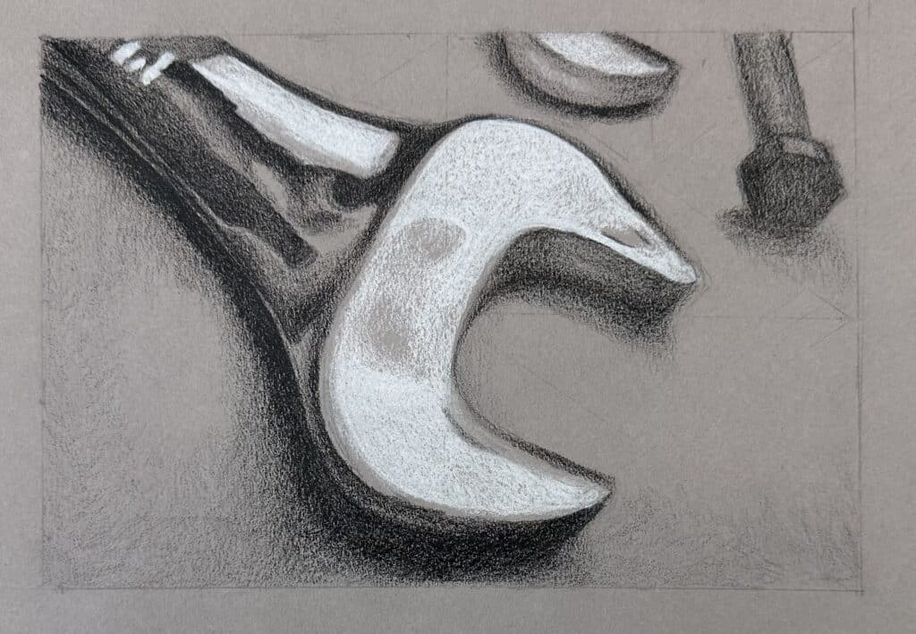 High contrast charcoal still life drawing of a wrench on gray paper