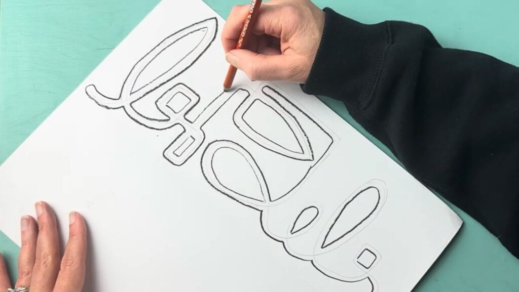 Trace your initial celtic knot sketch with a charcoal or graphite pencil and make sure to press hard