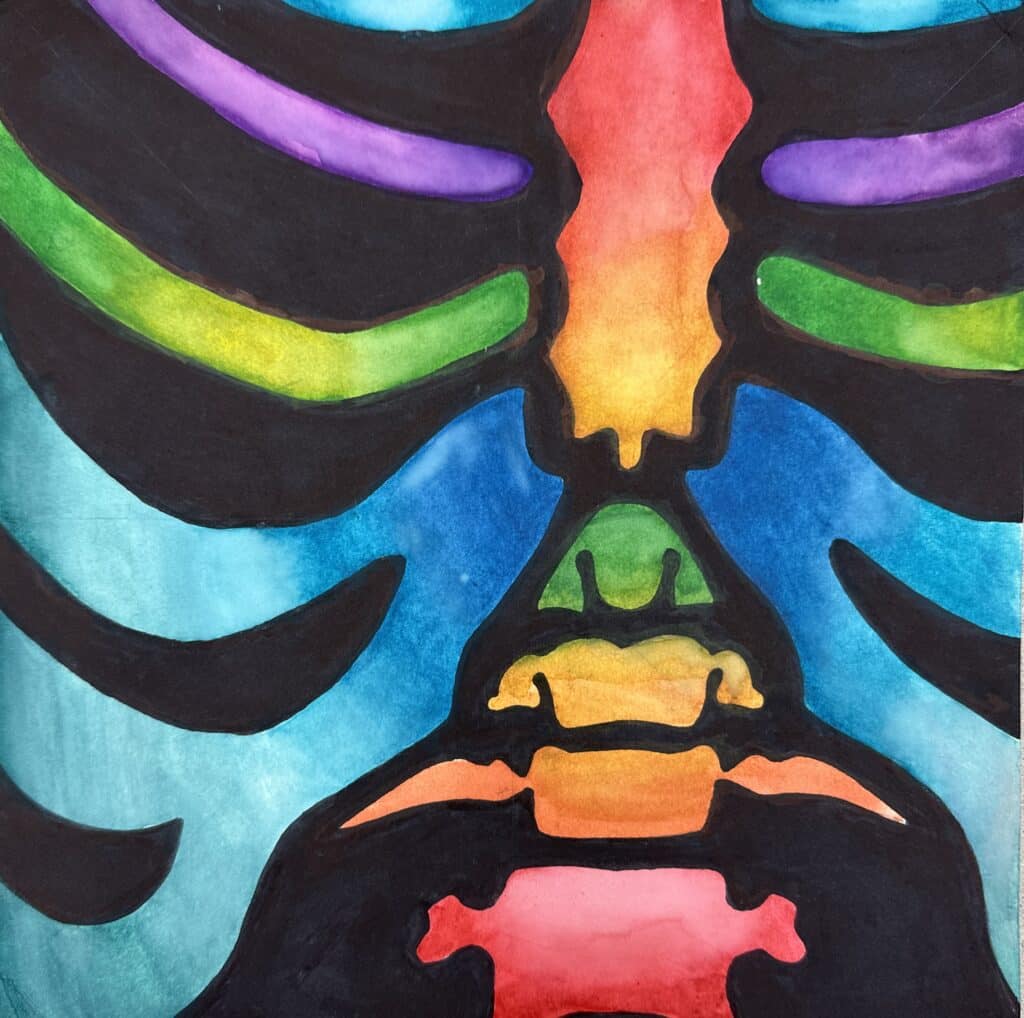 Student example of a high school art curriculum symmetry project showing a colorful skeleton design with bold black shapes, mirrored composition, and watercolor or colored pencil blending.