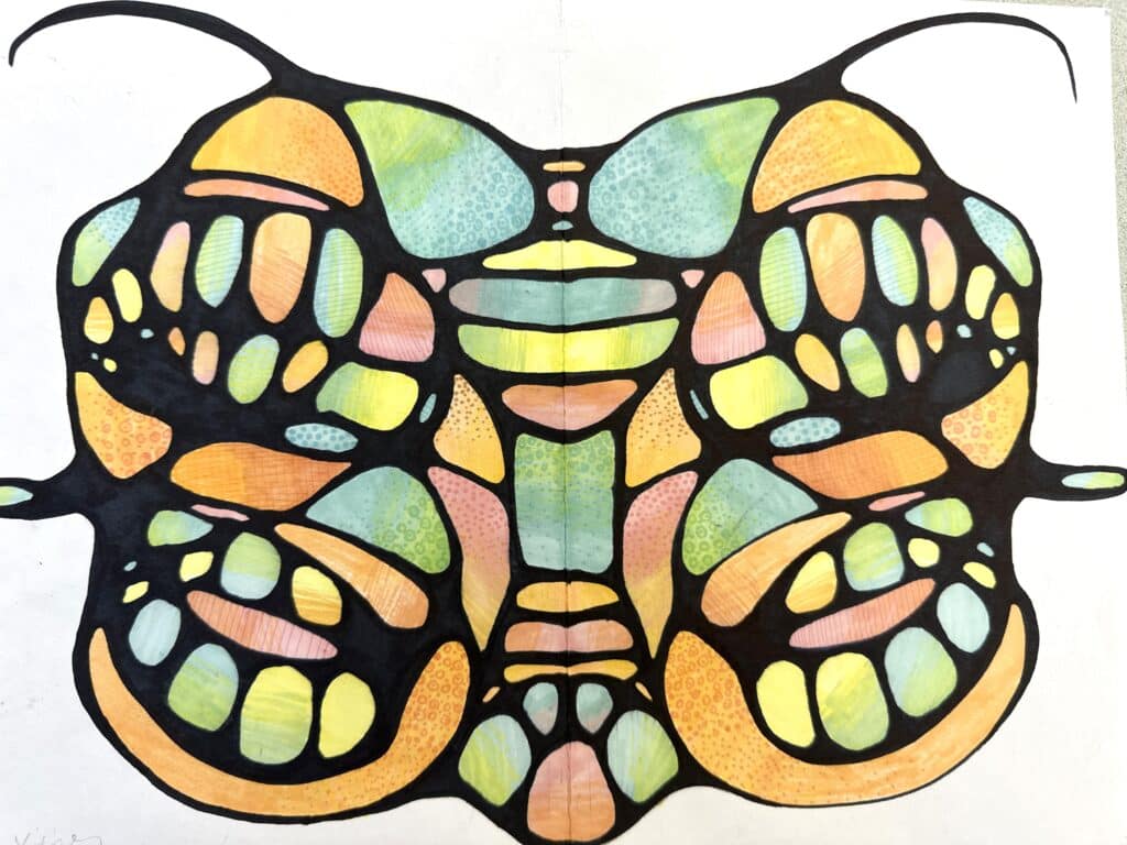 Student example of a high school art curriculum line and color design project featuring a symmetrical butterfly with bold black outlines and colored pencil shading.